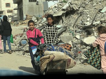 Girls carrying winter assistance items provided to them in Gaza city, 13 March 2025. Photo by OCHA/Olga Cherevko